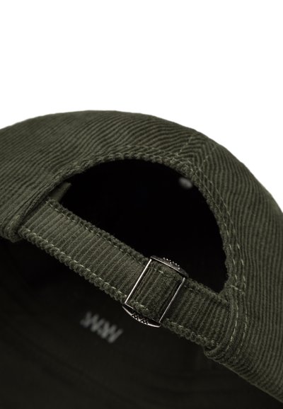 Zaļš kordūrēts cepure ar izliekta viziera, regulējama siksna un metāla sprādzes detaļa. Iekšpusē ir piešūta birka.