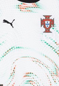 Maglietta sportiva bianca con colletto rotondo nero, caratterizzata da un motivo a pois verdi e arancioni. Include il logo Puma nero e lo stemma nazionale del Portogallo.
