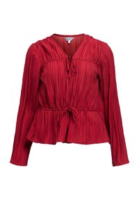 Blusa rossa a maniche lunghe con pieghe verticali, chiusure a cravatta al collo e in vita, e orlo leggermente svasato.