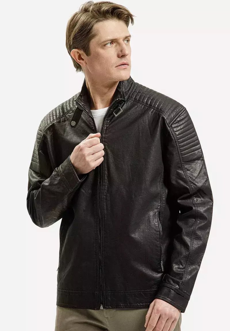 Czarna skórzana kurtka z pikowanymi ramionami, stójką i zapięciem na zamek. Gładka tekstura, dopasowany krój i minimalistyczne akcenty sprzętowe.