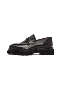 Mocasines de cuero negro con punta redondeada, una correa decorativa con herrajes metálicos y una suela negra gruesa con relieve para mayor agarre.