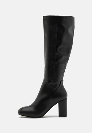 Botte noire hauteur genou avec une finition en cuir lisse, bout carré et un talon épais. Le design présente une silhouette élégante et ajustée.