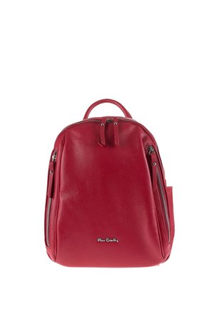Zaino in pelle rossa con due tasche frontali verticali con cerniera e manico superiore, sfondo semplice, piccolo logo in metallo sulla parte frontale inferiore centrale.
