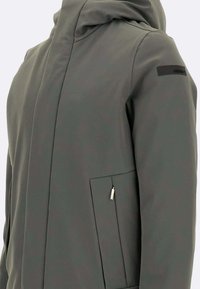 Giacca grigia con cappuccio e texture liscia, dotata di una tasca con zip e un design elegante. Accenti neri sottili sulle maniche.