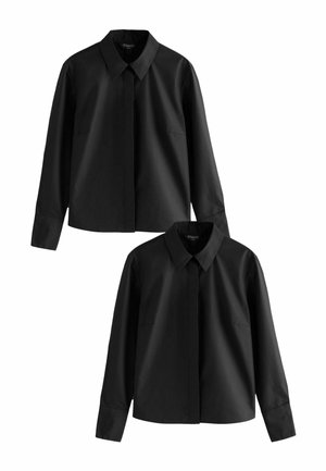 Camisa negra de botones con collar puntiagudo, mangas largas y dos bolsillos frontales. Fabricada en una tela suave con un diseño clásico y estructurado.