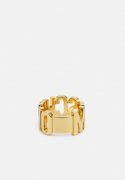 Gouden metalen ring met uitsnijdingen van letters en een gladde, gepolijste afwerking. Het ontwerp toont een open structuur met vetgedrukte karakters.