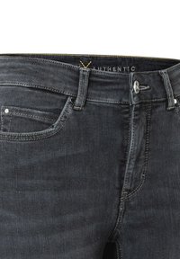 Jeans de mezclilla negra con cremallera, cierre de botón, diseño de cinco bolsillos y detalles de costura amarilla a lo largo de la cinturilla y los bolsillos.