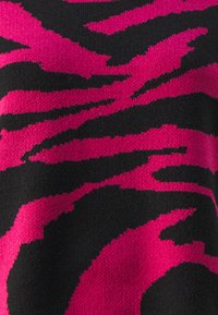 Stickad tröja med ett mönster av rosa och svarta tigerstripes. Mjuk textur med djärva kontrasterande färger, vilket skapar en dynamisk visuell effekt.