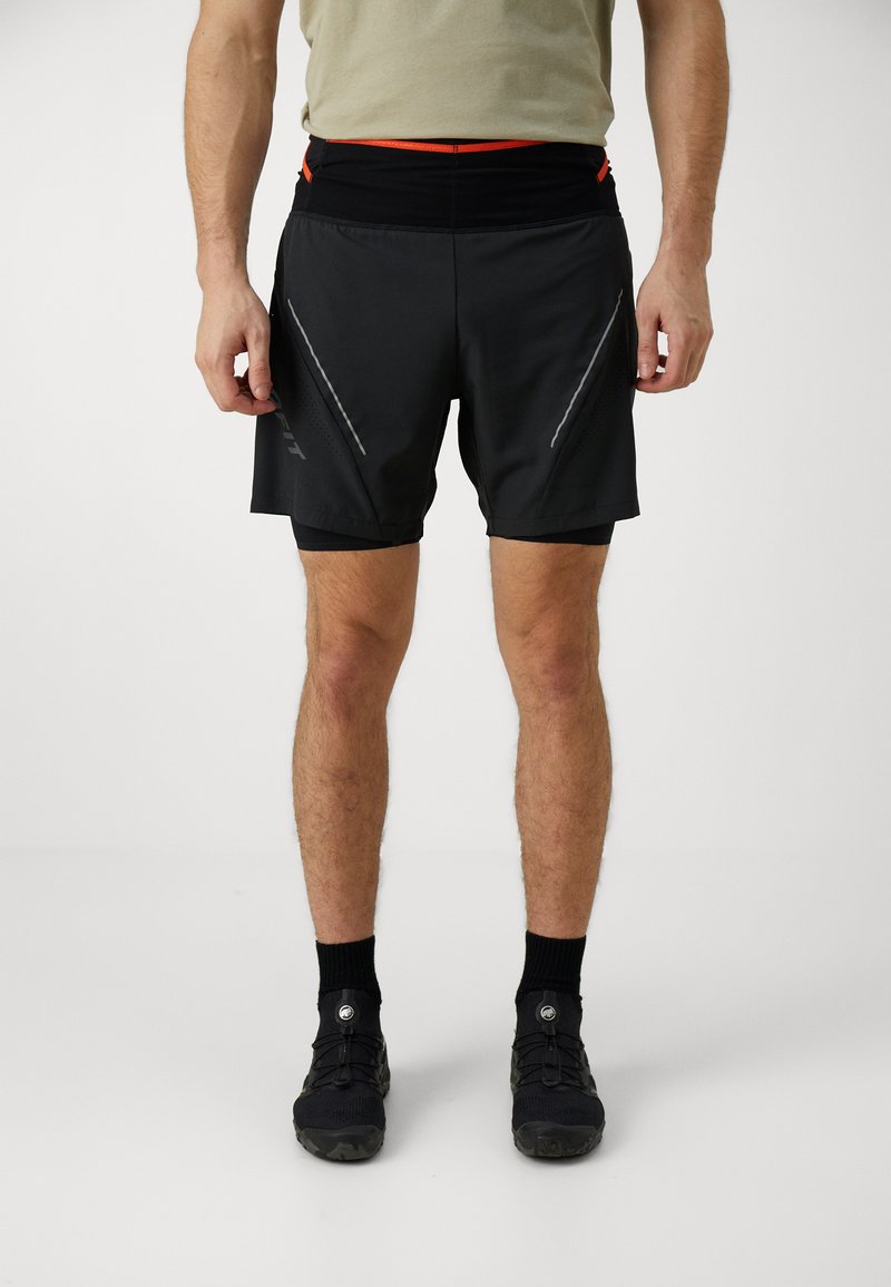 Shorts de sport noirs avec des accents réfléchissants et une taille texturée ; conçus avec des poches latérales et des shorts intérieurs intégrés.