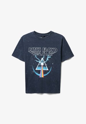 T-shirt nera in cotone con stampa grafica raffigurante un triangolo con raggi arcobaleno, dettagli blu e le parole "Pink Floyd" e "The Dark Side of the Moon."