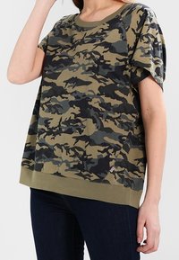 Camo-mønstret t-shirt i olivengrøn, sort og grå. Fremstillet af blødt stof, med rund hals og korte ærmer, i en afslappet pasform.