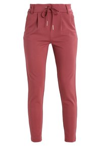 Roze, uitlopende broek van gladde stof. Heeft een strik aan de voorkant met metalen accenten en twee zijzakken.
