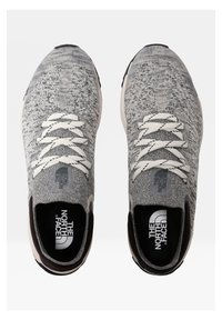 Šedé pletené tenisky s texturovaným vzorem, bílými tkaničkami a černými doplňky. Logo je viditelné na jazyku a stélce. Pryžová podešev.