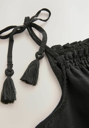 Crni materijal s nabranom detaljnom obradom ima dva remena s rese. Tekstura izgleda glatko, a dizajn je jednostavan i funkcionalan.