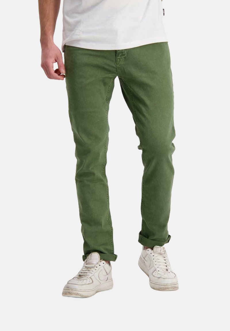 Groene katoenen chinos met een slim fit, voorzien van een ritssluiting, vijf pockets en opgerolde manchetten, gecombineerd met witte sneakers.