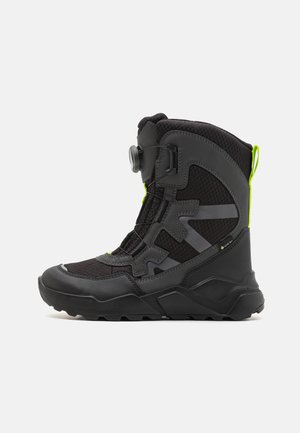 Schwarzer und grauer wasserdichter Stiefel mit einer strukturierten Oberseite, fluoreszierenden grünen Akzenten und einem sicheren Verschlusssystem vorne. Gummisohle.