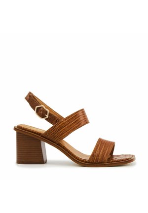 Sandale à talon synthétique marron avec un motif crocodile texturé, deux larges brides sur le pied et une petite bride de cheville avec une boucle dorée.