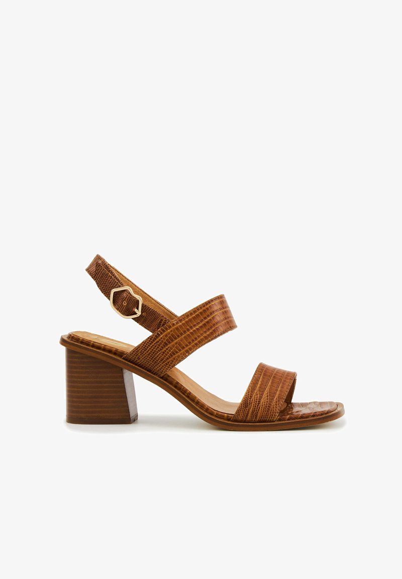 Sandale à talon synthétique marron avec un motif crocodile texturé, deux larges brides sur le pied et une petite bride de cheville avec une boucle dorée.