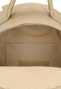 Interno della borsa beige con materiale sintetico testurizzato, chiusura con zip e tasca piatta. Fodera liscia senza modelli o hardware visibili.