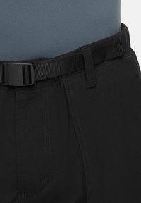 Zwarte broek met een gladde structuur, voorzien van een zijzak en een geribbelde zwarte riem. De tailleband lijkt elastisch te zijn voor een verstelbare pasvorm.