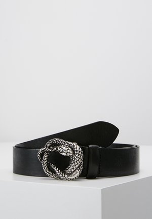 Ceinture en cuir noir avec une boucle argentée en forme de serpent enroulée en cercle, posée sur une surface blanche sur un fond uni.