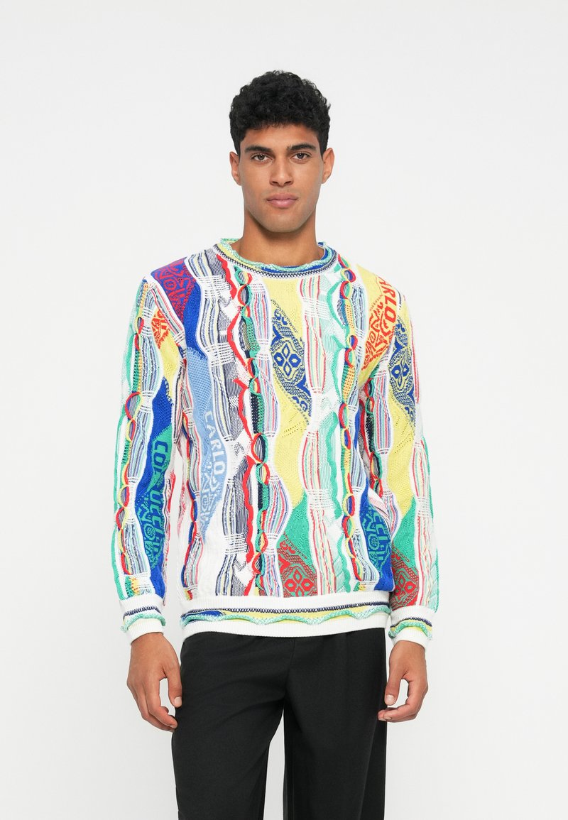Πλεκτό πουλόβερ με πολύχρωμο γεωμετρικό μοτίβο σε μπλε, κόκκινο, πράσινο και κίτρινο. Ριμπάριστο μανίκι και στρίφωμα, στρογγυλή λαιμόκοψη, υφή υφάσματος.