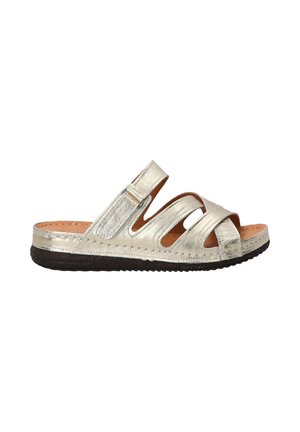 Metallic silver slide sandal with cut-out design, adjustable strap, and textured sole. Features a soft leather footbed and flat heel.