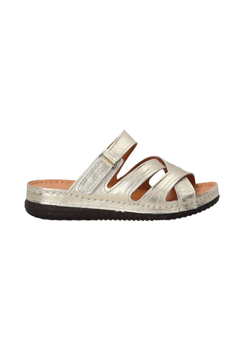 Metallic sølv slidesandal med udskæringsdesign, justerbar rem og tekstureret sål. Har en blød læderfodseng og flad hæl.