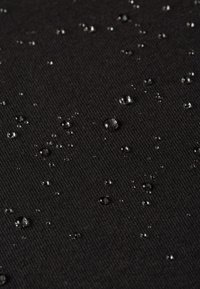 Zwarte gestructureerde stof met kleine waterdruppels op het oppervlak, die een vochtbestendige eigenschap en een fijn ribbelpatroon tonen.