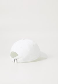 Λευκό καπέλο μπέιζμπολ απεικονιζόμενο από πίσω με ρυθμιζόμενο λουράκι και μεταλλικό κούμπωμα, σε απλό λευκό φόντο.