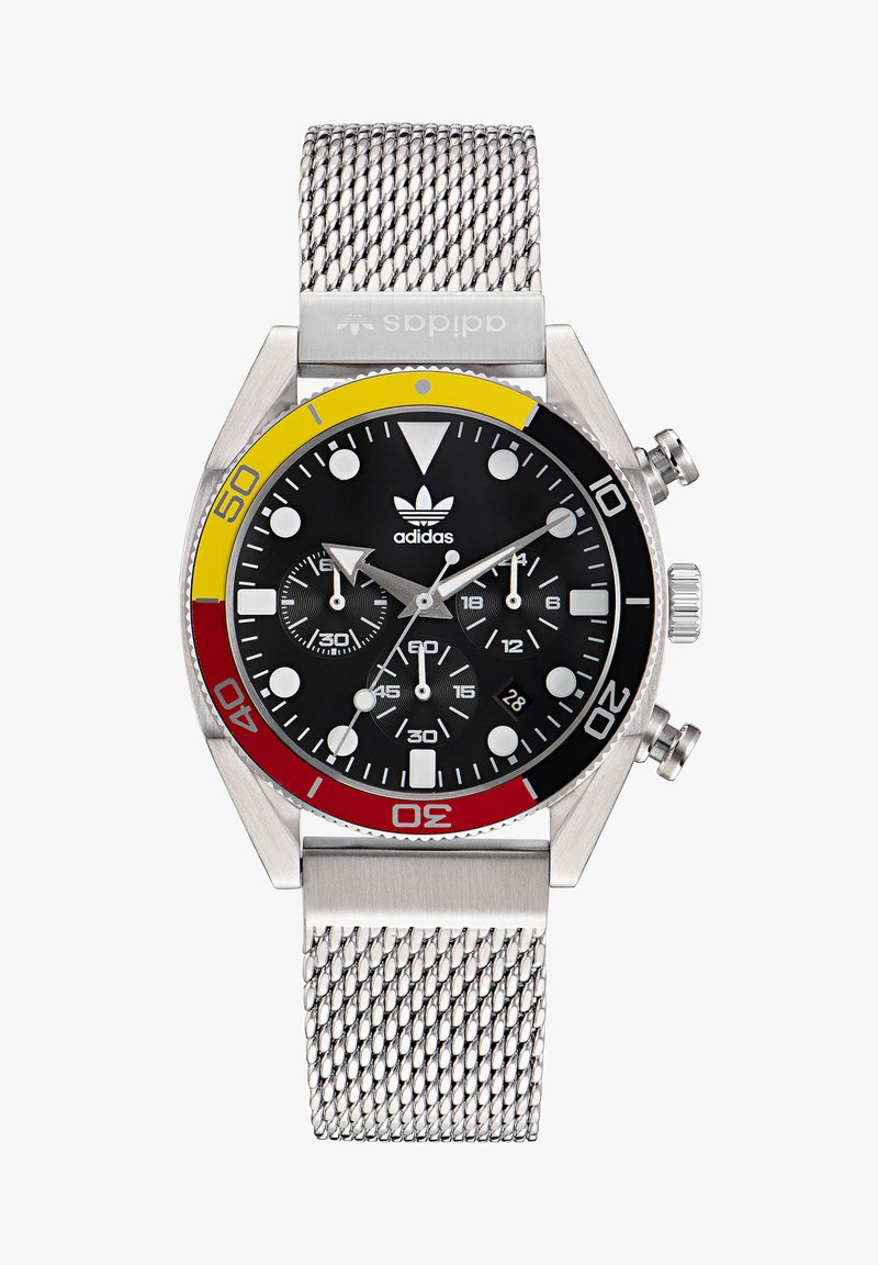 Nerūdijančio plieno laikrodis su juodu ciferblatu, ryškiomis baltomis žymėmis ir chronografu. Papuoštas raudonomis, geltonomis ir sidabrinėmis detalėmis. Tinklinis dirželis.