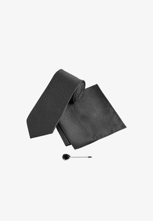 Black patterned necktie and matching pocket square with a teardrop-shaped black lapel pin on a white background.