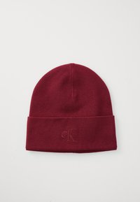 Burgundy knit beanie with a folded cuff and embroidered "ck" logo on the front. Soft texture, snug fit, and simple, streamlined design.