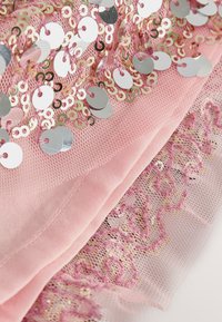 Pink fabric featuring silver and gold sequins on a mesh overlay, with delicate lace detailing and a smooth texture.