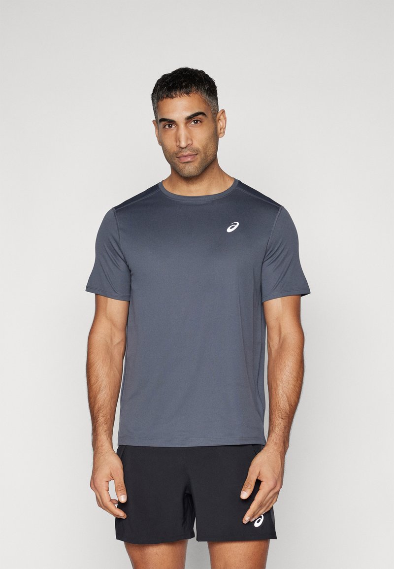 Graues Sport-T-Shirt mit Rundhalsausschnitt und kurzen Ärmeln, aus glattem, leichtem Stoff; hat ein kleines weißes Logo auf der Brust.