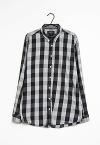 Camicia con maniche lunghe e colletto a bottoni in un pattern a scacchi nero e grigio. Presenta un colletto classico e un orlo arrotondato. Il tessuto sembra morbido e testurizzato.