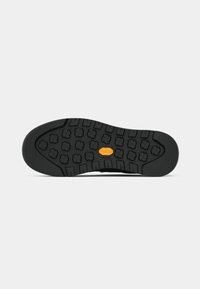 Black rubber outsole featuring textured tread pattern with circular and rectangular grips; Vibram logo in orange near the center.