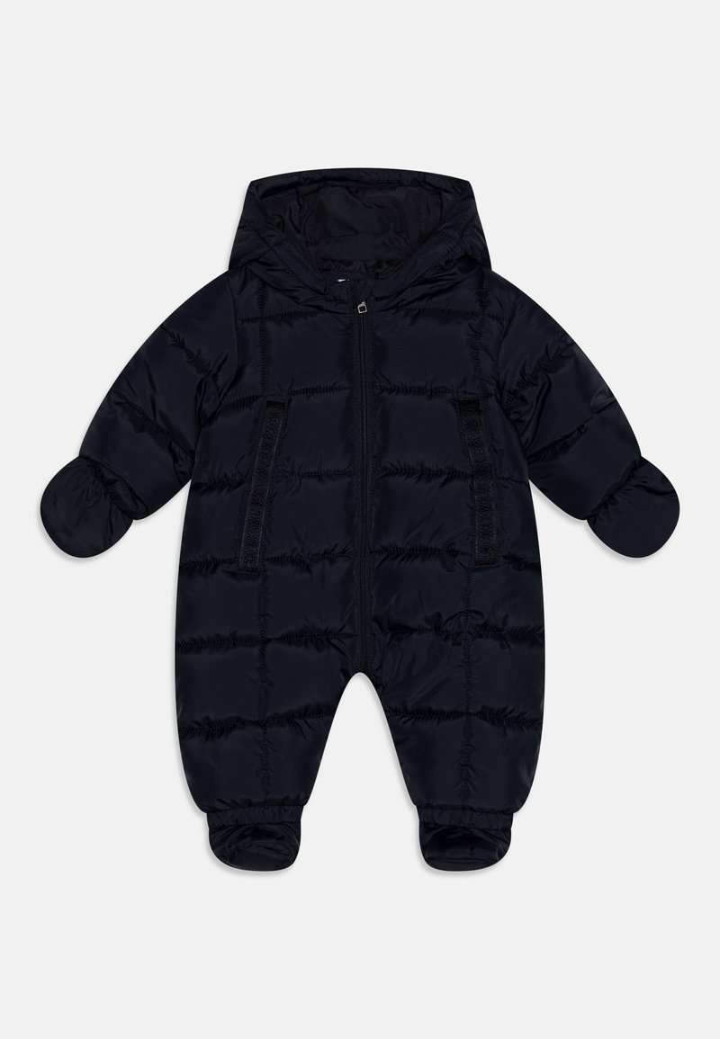 Combinaison de neige noire matelassée pour bébé avec capuche, moufles attachées, couvre-pieds et fermeture éclair centrale à l'avant, sur fond blanc.