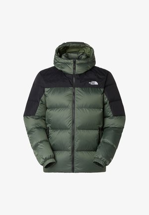 Groene geïsoleerde pufferjas met een zwarte bovenkant, capuchon, ritssluiting, elastische manchetten en logo op de linker borst. Glad, glanzend stof.