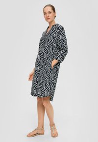 Navyblaues, gemustertes Kleid mit geometrischen weißen Linien, V-Ausschnitt, dreiviertel Ärmeln, Taschen und einer lockeren Passform.