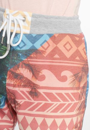 Shorts de bain avec une ceinture élastique grise et un cordon de serrage blanc. Motifs tropicaux et géométriques multicolores, incluant des feuilles de palmier et des vagues.