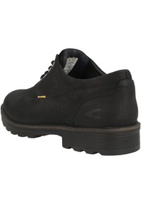 Scarpa in pelle nera con tomaia texturizzata, punta rotonda e suola in gomma spessa. Presenta un accento dorato e un design con lacci.