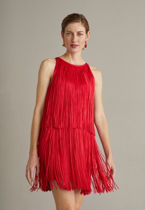 Robe sans manches rouge avec de longs franges, un col rond et un design fluide qui atteint mi-cuisse, créant du mouvement et de la texture.