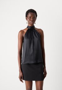 Čierny halter top z saténovej látky s zhromaždeným výstrihom, s voľným strihom a hladkou textúrou, spárovaný s jednoduchou čiernou mini sukňou.