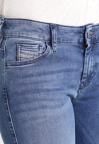 Bleknade blå denimjeans med en klassisk femficksdesign, som har en liten framficka och metallknappstängning.