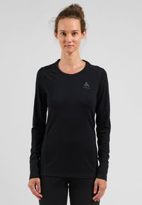 Black long-sleeve shirt made of smooth fabric, featuring a round neckline and subtle logo on the left chest. Adjusted fit for comfort.