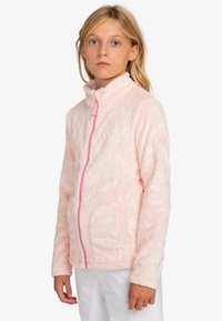 Chaqueta de forro polar rosa con alto cuello, cremallera frontal completa, bolsillos laterales y un patrón texturizado. Presenta una cremallera y un logo en rosa contrastante.