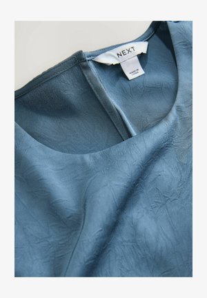 Modrá texturovaná blůza s kulatým výstřihem, vyrobená z lehkého materiálu, s jemnými vráskami a štítkem s označením "NEXT."