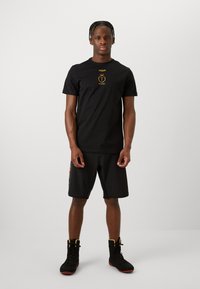 Venum UNMATCHED TOPURIA EDITION - Majica kratkih rukava s printom - black/antique gold