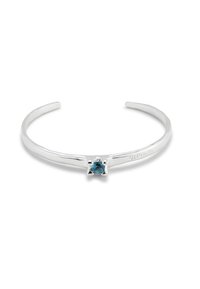 Brazalete de plata con piedra preciosa azul central, textura suave, diseño minimalista y extremos suavemente redondeados.